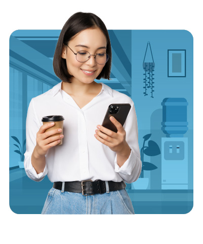 A young woman wearing glasses holds a cup of coffee in one hand and smiles at her smartphone in the other. She stands in a modern office setting with a blue-tone background.