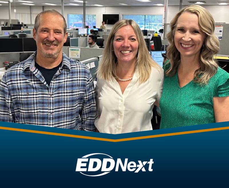Man and two women posed and smiling for the camera with the EDDNext logo