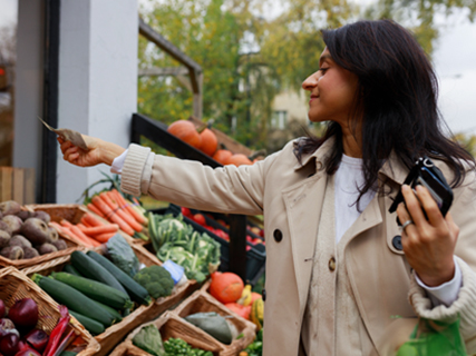 image of woman shppping at a farmers/street vegetable market