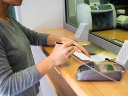 image of woman making a bank transactoin at a teller window