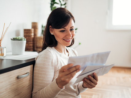 image of a smiling woman reading papers at a desk