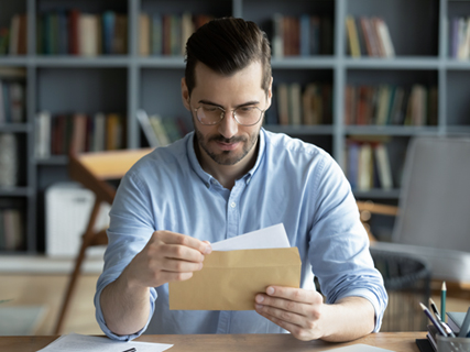 image of a man reading papers at a desk